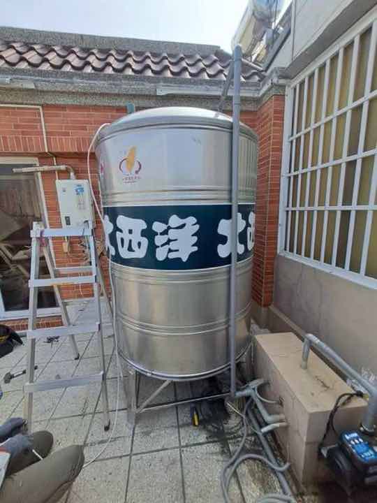 設配安裝:透天厝外吊車作業中,準備吊運頂樓水塔施工。