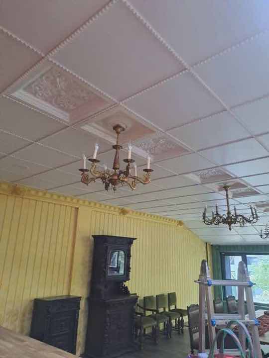 設配安裝:古典餐廳天花板安裝兩盞銅製多臂吊燈,搭配格狀造型天花與黃色壁板。