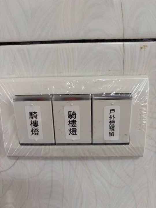 明管配線：Panasonic 三聯燈具開關新安裝，現場貼上戶外燈預留／騎樓燈／騎樓燈手寫標籤便於辨識。